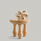 Gold decorative item on a wooden stand in a room with chairs and a table.