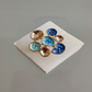 Pair of earrings with blue and gold stones on a white card