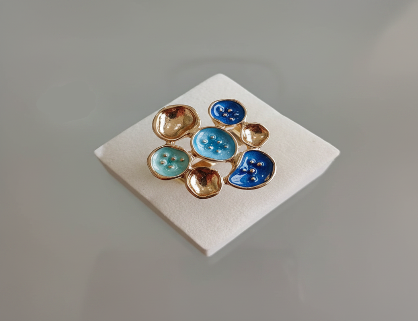 Pair of earrings with blue and gold stones on a white card